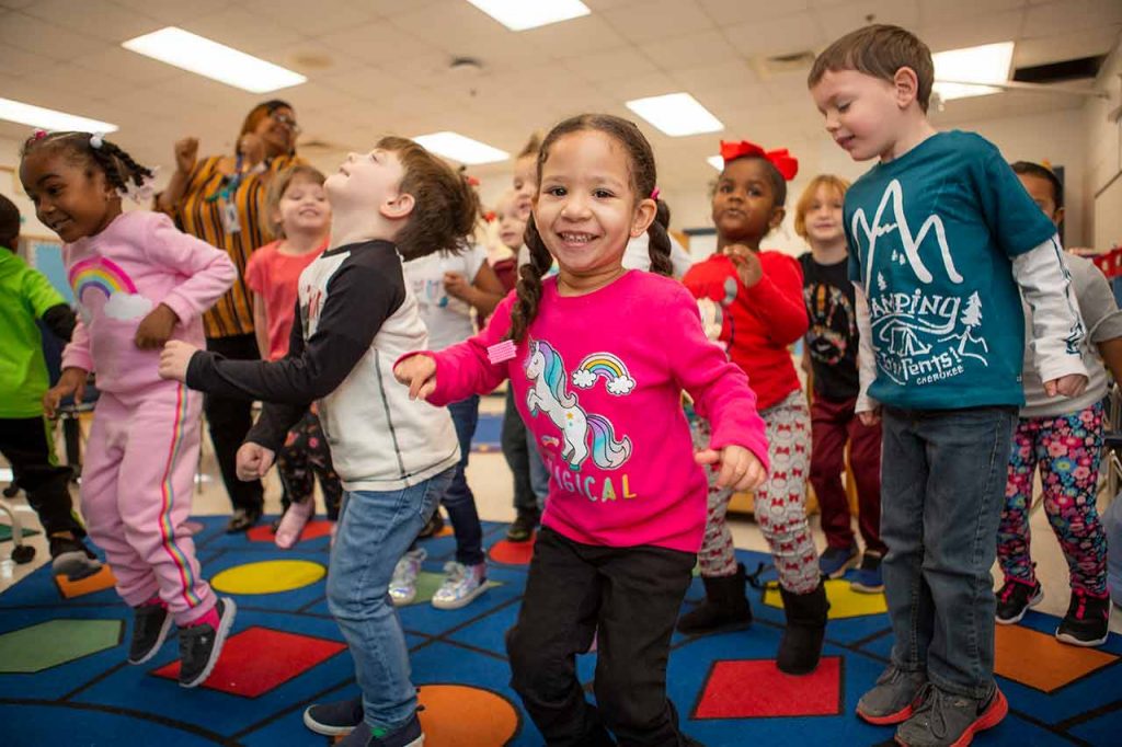 Children in the classroom jumping up and down