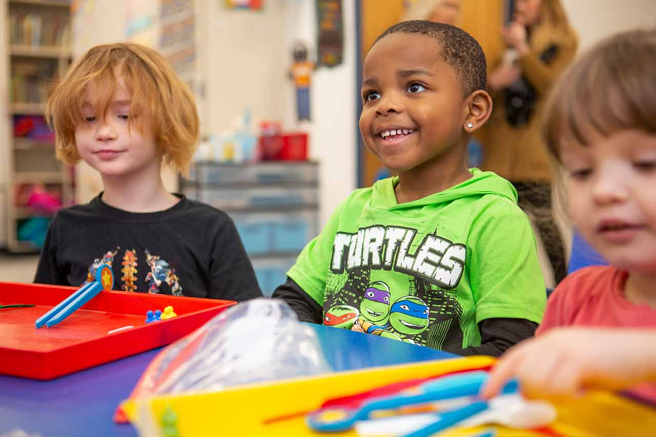 three preschool boys sitting at a table