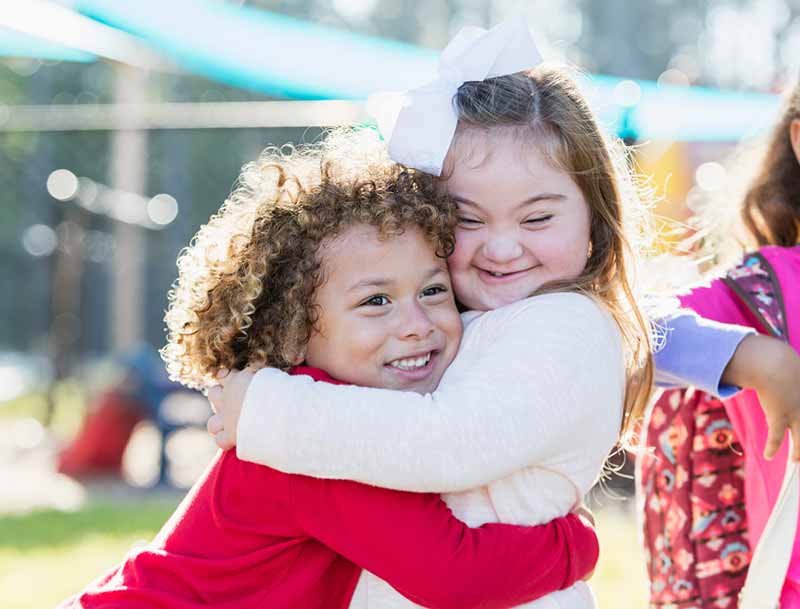 two children hugging on playground