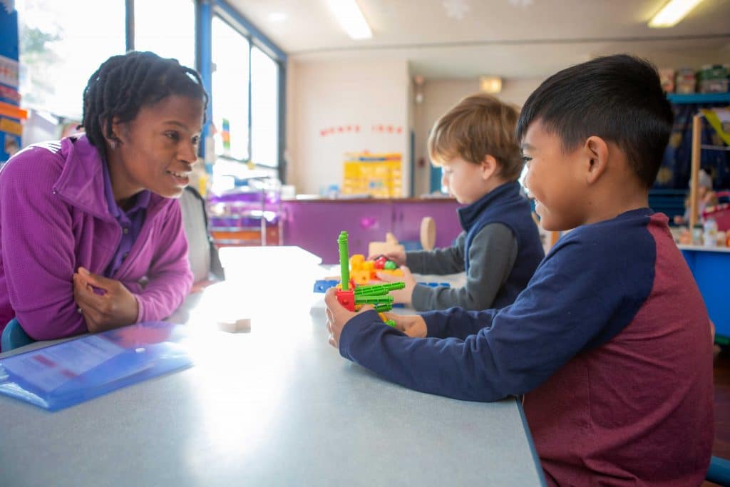 Teacher encouraging a child while he plays