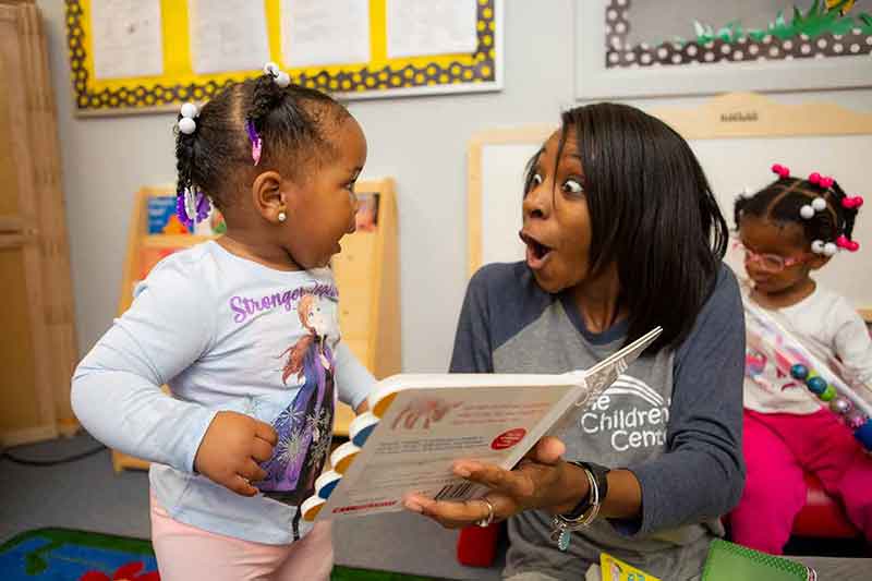 young girl and toddler reading book