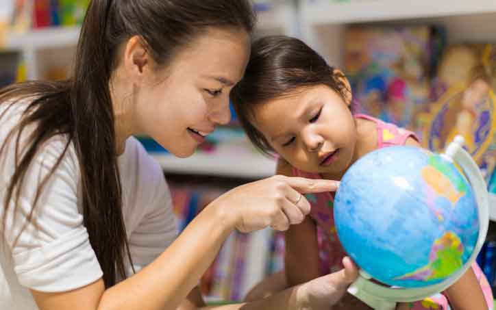 Teacher and child looking at globe